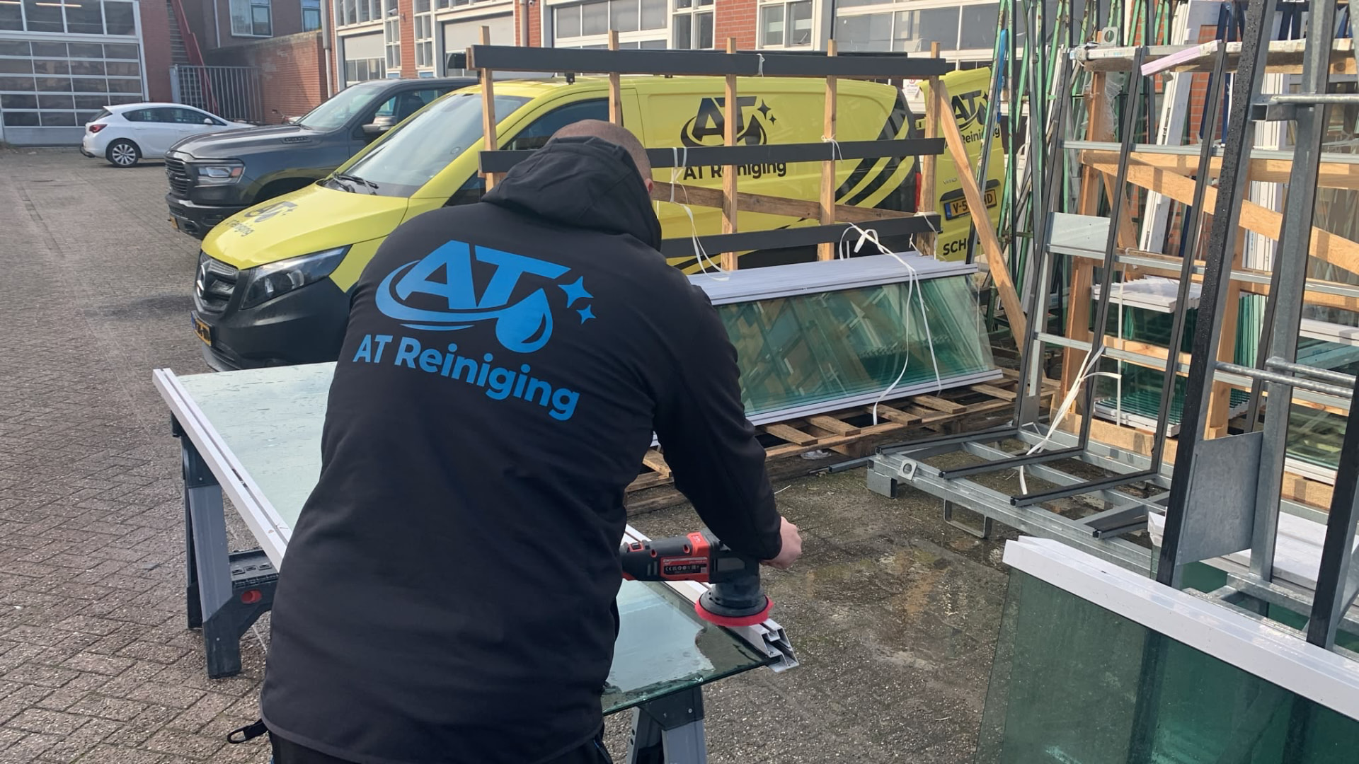 AT Reiniging polijst een ruit in de werkplaats
